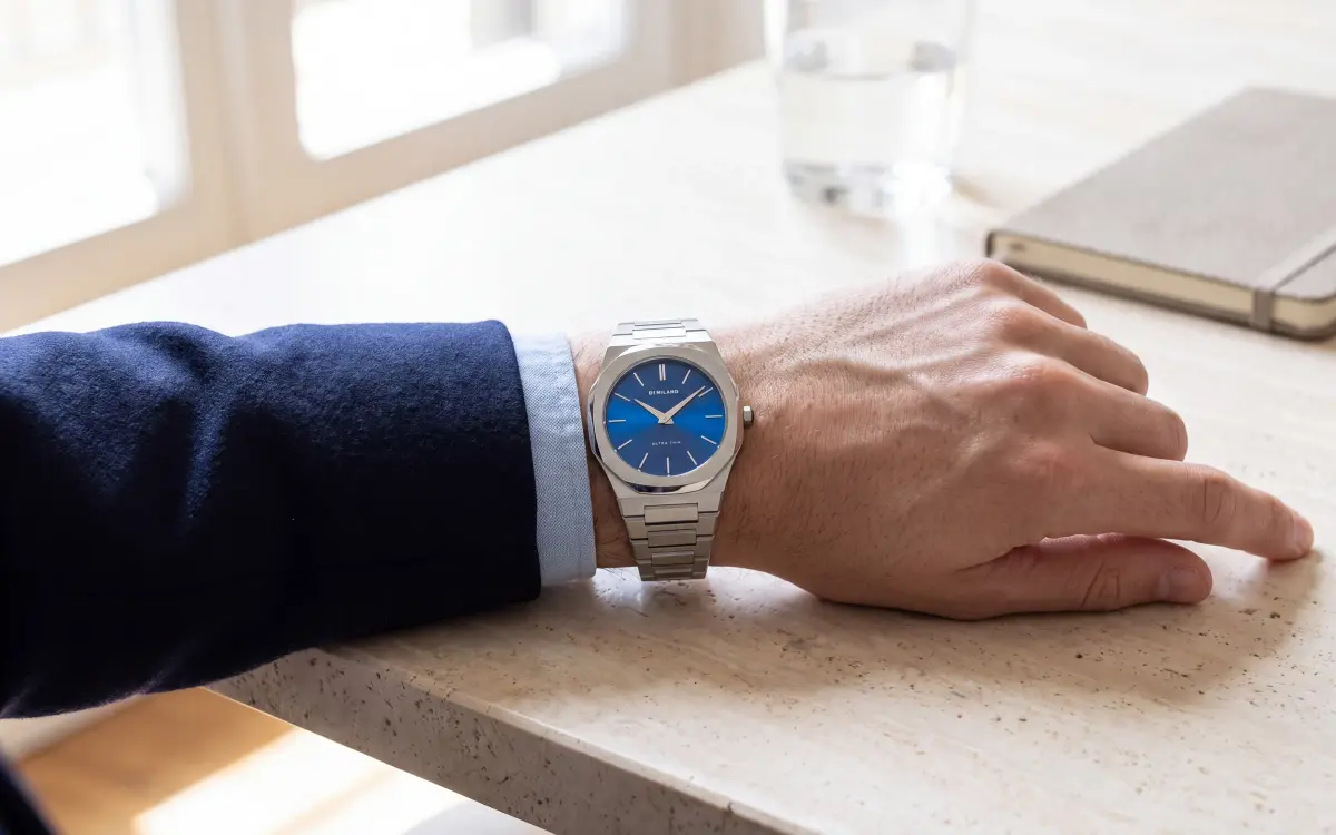 Montre octogonale homme D1 Milano Ultra Thin UTBJ09 cadran bleu soleillé portée avec un blazer bleu marine, alternative accessible à la Royal Oak