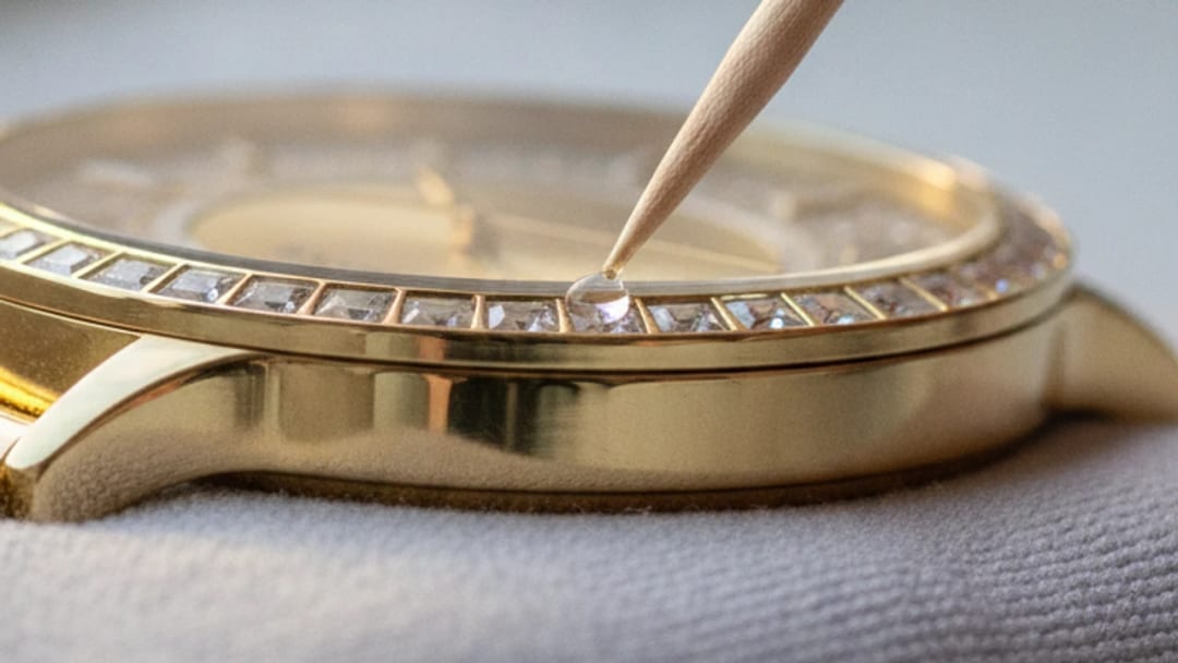 Tip of a toothpick depositing a micro-drop of clear varnish at the edge of a set crystal
