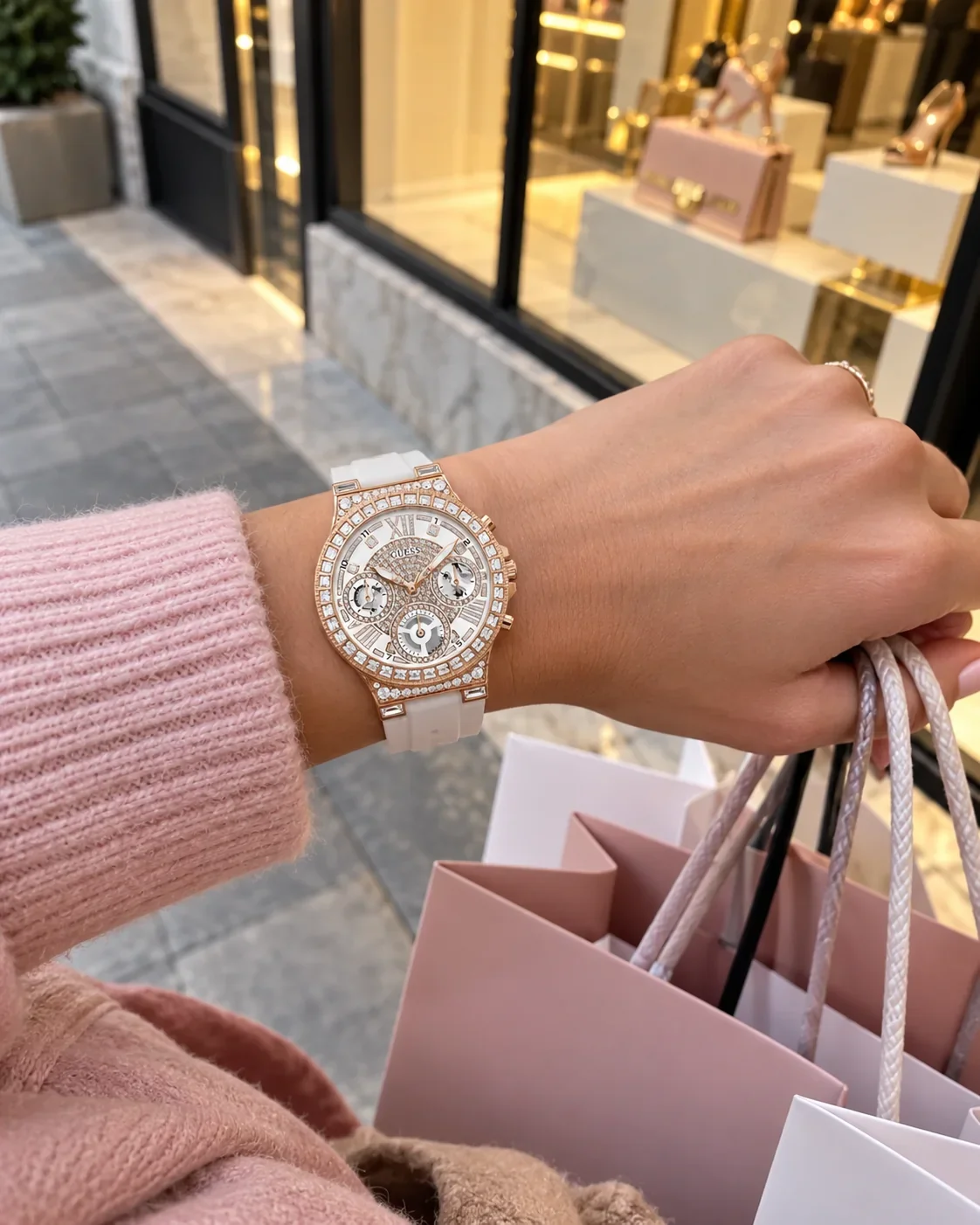 Montre Guess GW0257L2 femme portée au poignet, devant une vitrine de boutique