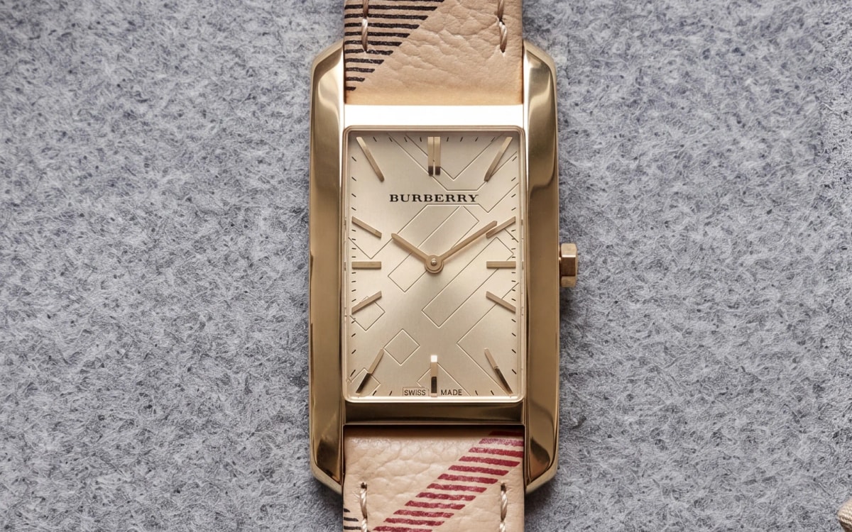 Burberry BU9407 rectangular gold-tone women's watch on a check canvas strap, on grey flannel
