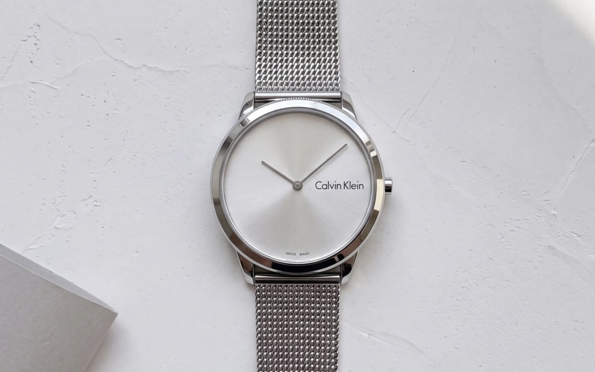 Calvin Klein Minimal K3M211Y6 steel watch with a plain silver dial and Milanese mesh, on white plaster