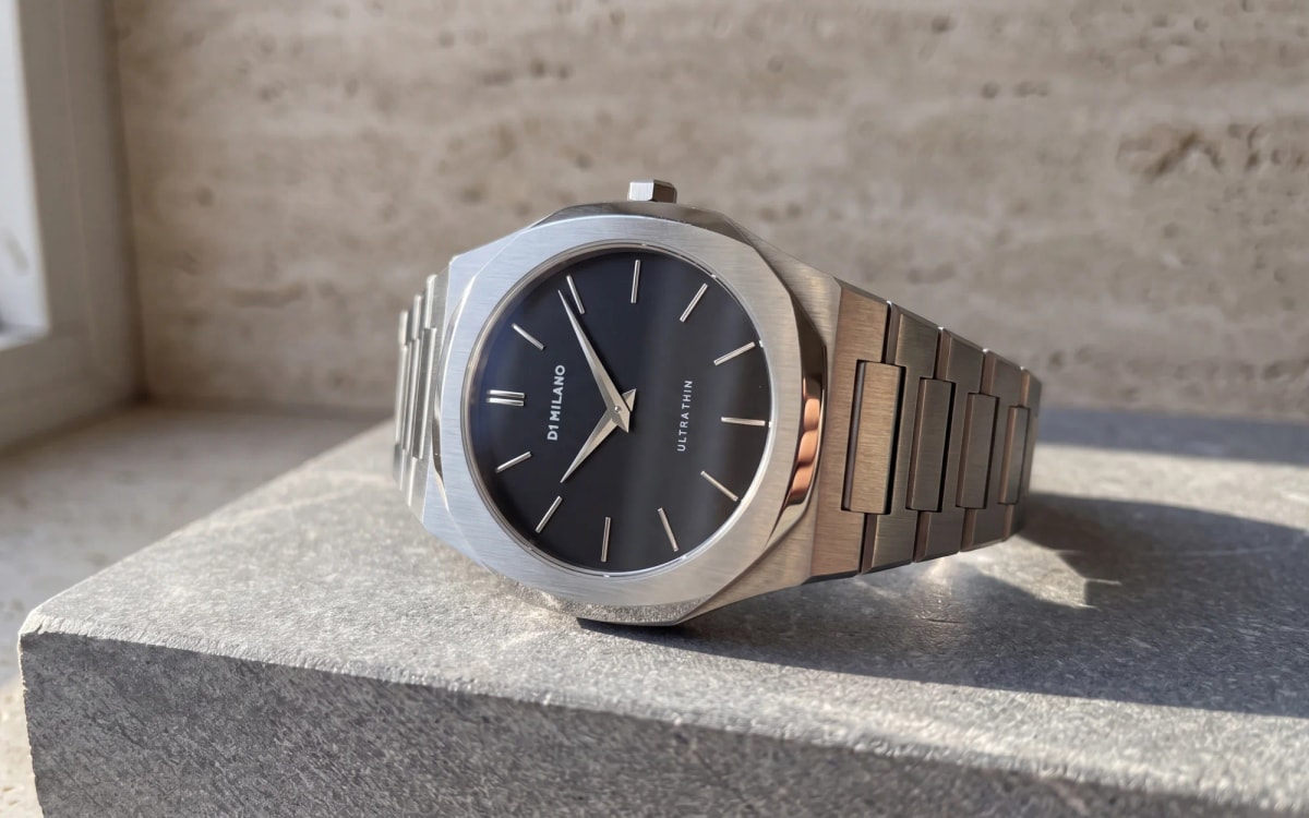 Brushed octagonal bezel of a steel D1 Milano Ultra Thin with a black dial resting on stone