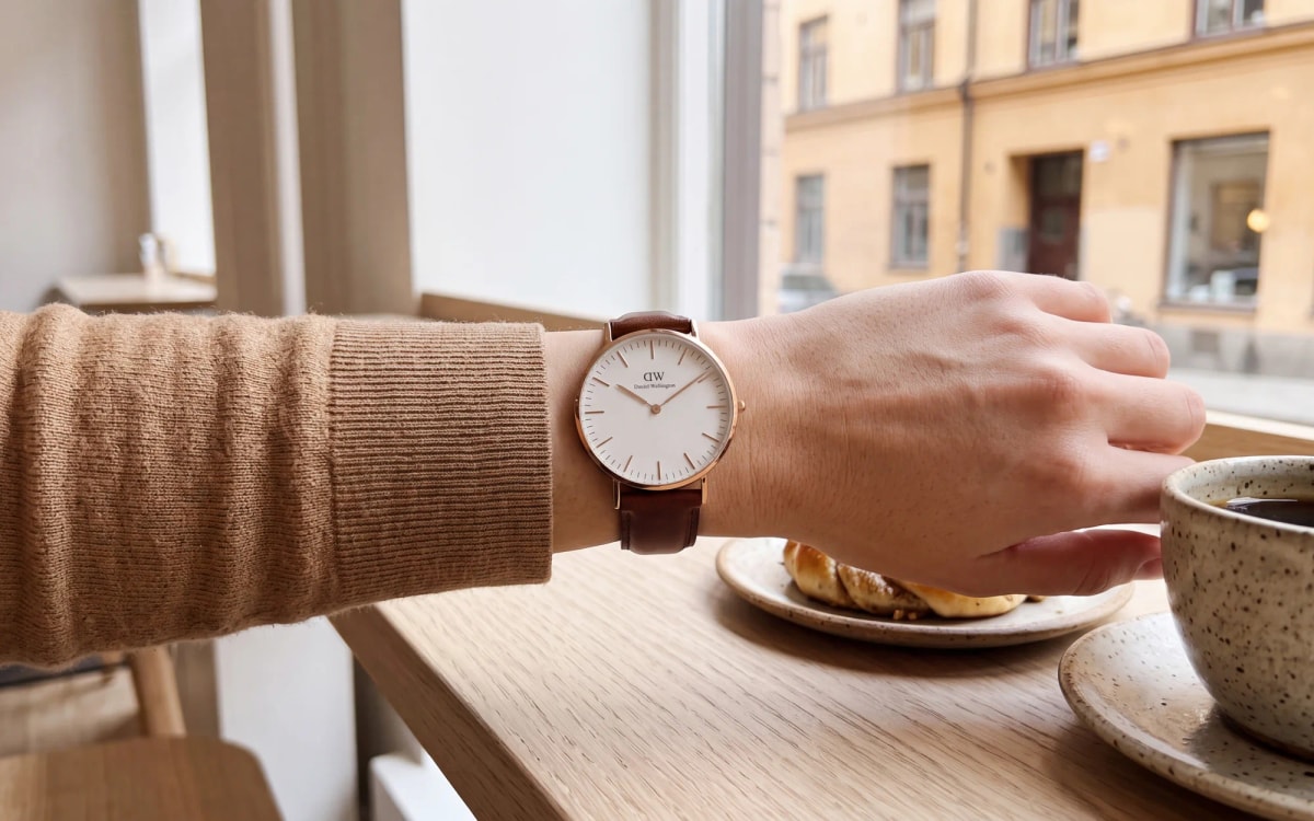 Daniel Wellington Classic 36 mm rose gold watch with a white dial worn in a Stockholm café