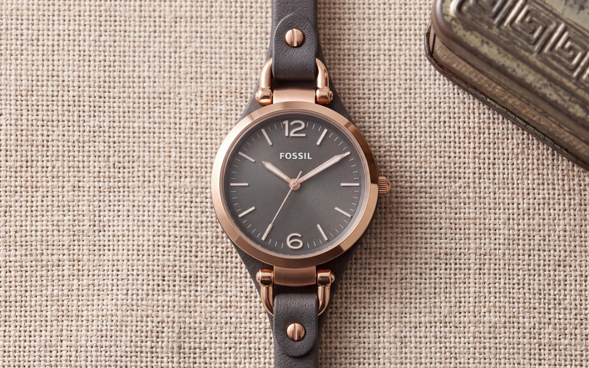 Fossil Georgia ES3077 rose gold women's watch with grey dial and grey leather on linen beside a tin box