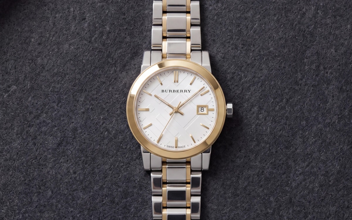 Montre femme Burberry The City BU9115 bicolore acier et or, cadran blanc, sur flanelle anthracite