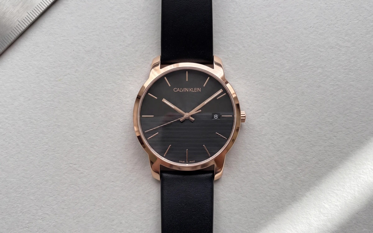Montre homme Calvin Klein City K2G2G6CZ or rose, cadran noir à demi rainuré, cuir noir sur papier gris perle