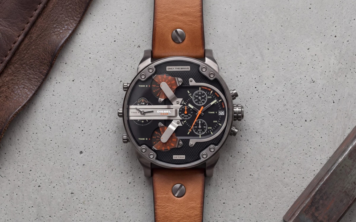 Diesel Mr Daddy DZ7332 gunmetal watch with black dial, orange accents and tan leather strap on raw concrete