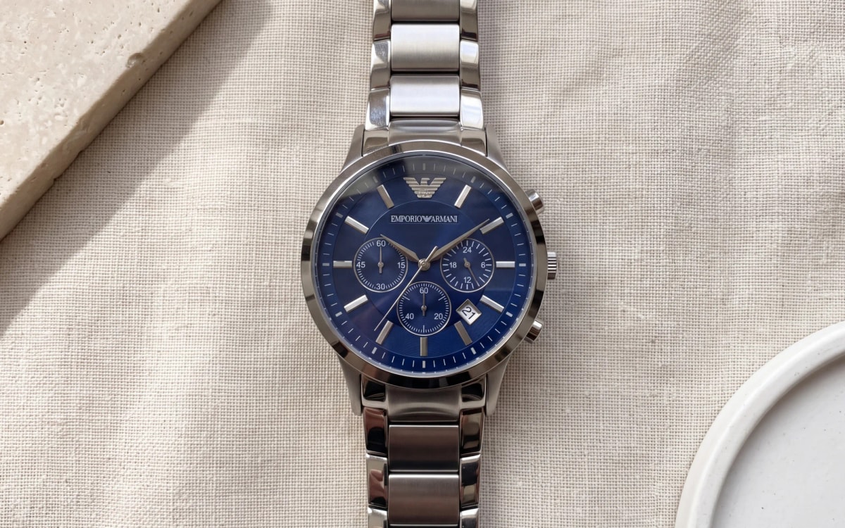 Montre homme Emporio Armani Renato AR2448, chronographe en acier à cadran bleu, posée sur du lin écru