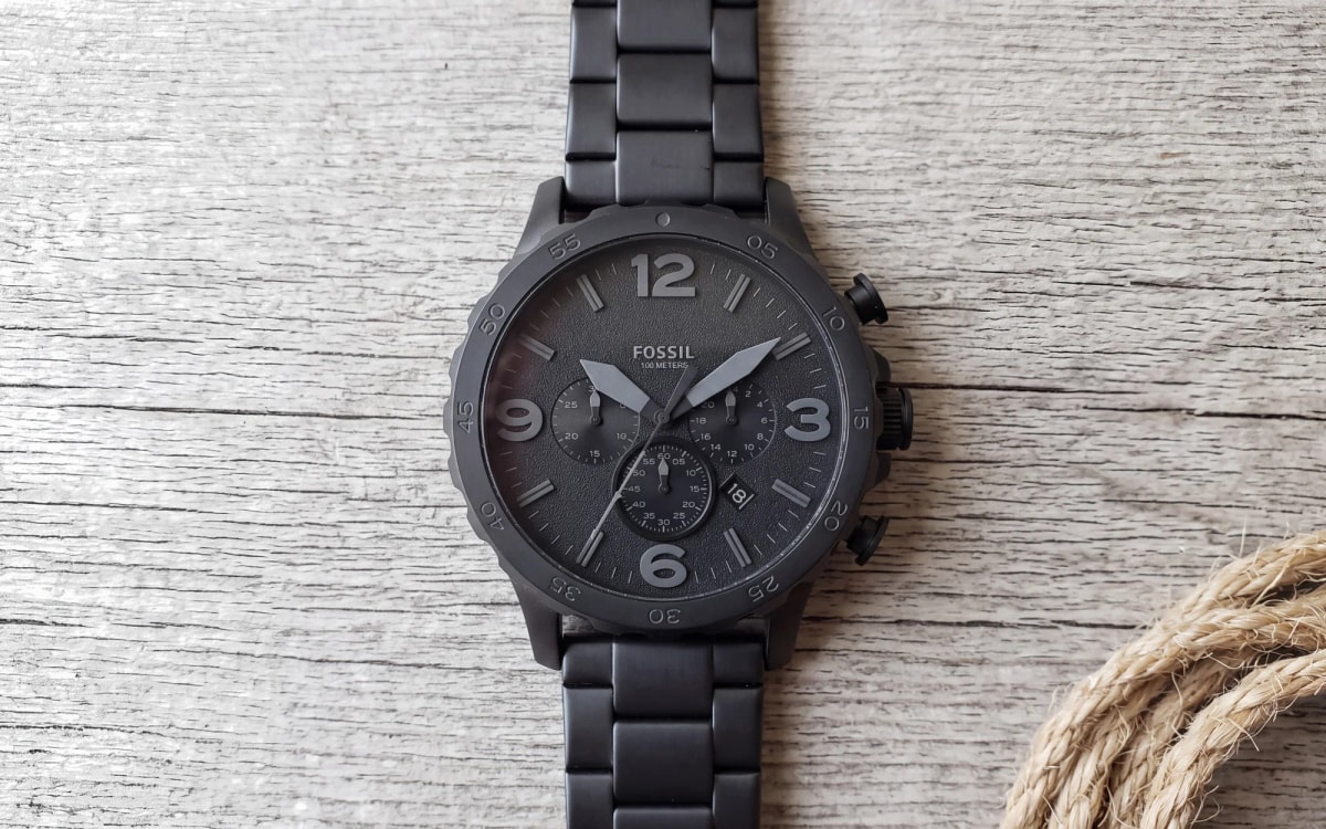 Montre homme Fossil Nate JR1401 noire de 50 mm, chronographe posé sur bois grisé près d'une corde de chanvre