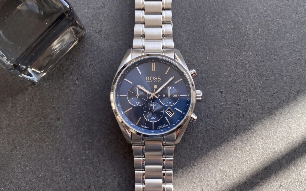 HUGO BOSS Champion 1513818 steel men's chronograph with blue dial on anthracite concrete beside smoked glass