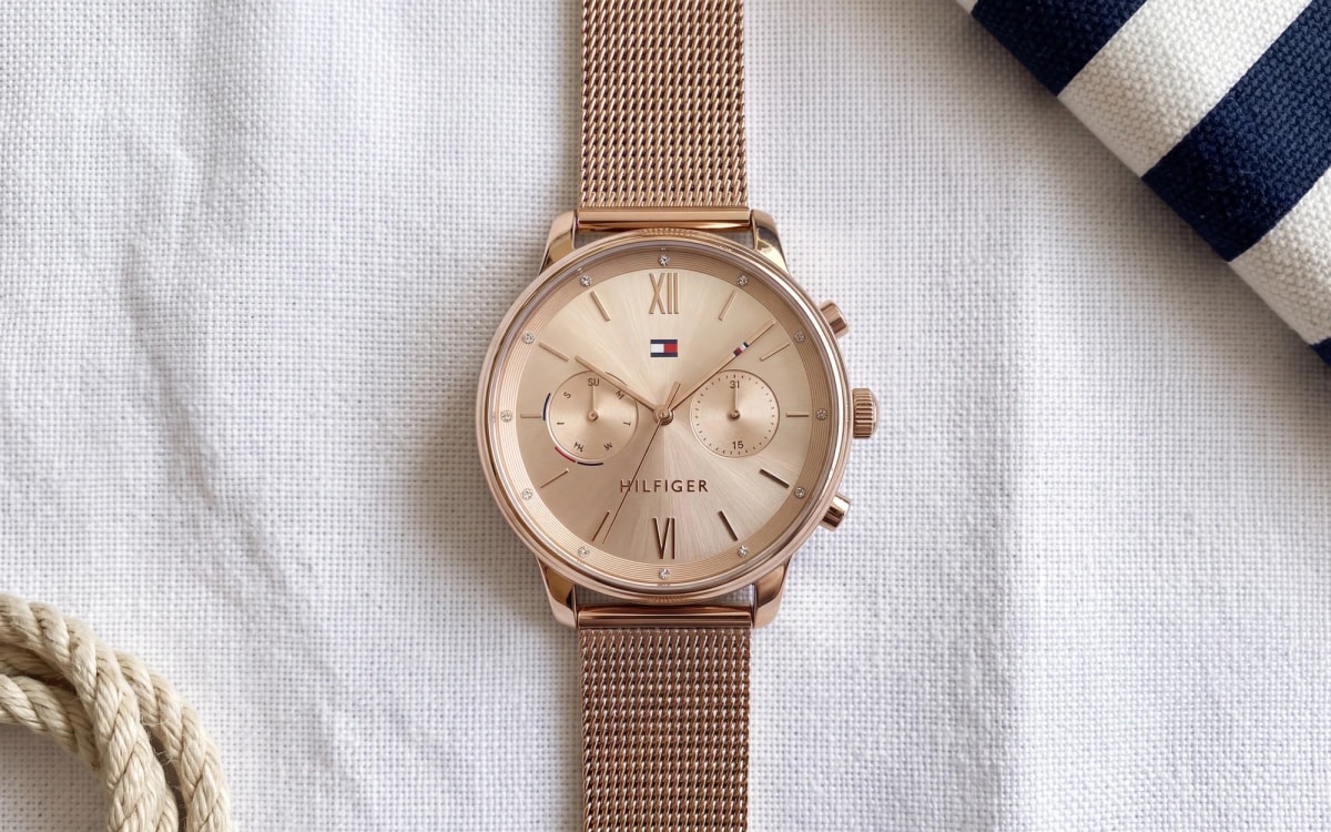 Montre femme Tommy Hilfiger Blake 1782303 or rose, chiffres romains et maille milanaise, posée sur du lin blanc